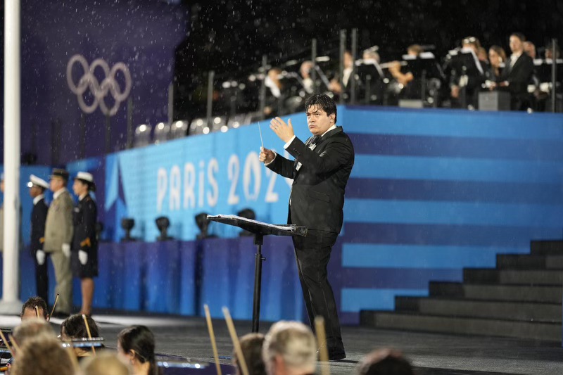 Cristian Mǎcelaru conducts at the 2024 Paris Olympics Opening Ceremony